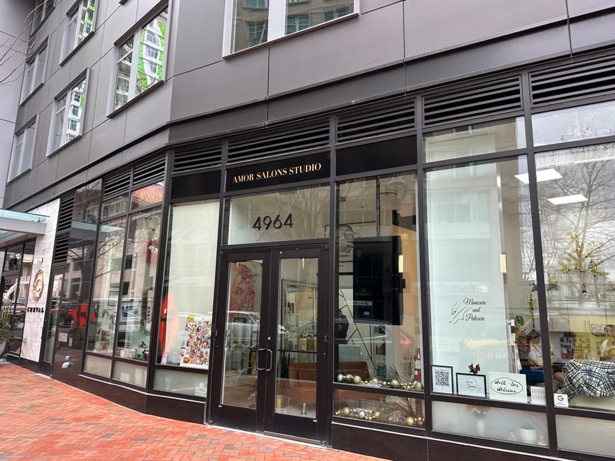 The Amor Studio Salons shopfront at 4964 Fairmont Avenue, Bethesda: a dark glazed frontage with the gold lettering on the granite pier beside the door.